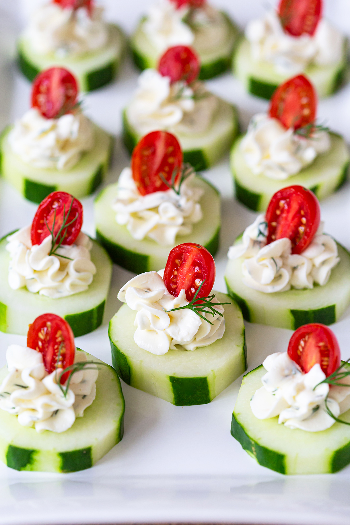 CUCUMBER BITES WITH HERB CREAM CHEESE AND CHERRY TOMATOES